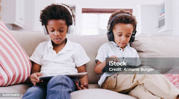Tablet Headphones And Relax Black Children On Sofa Playing Online Games Streaming Music Audio Or Watch Cartoon Movie Digital Device Gaming Technology And Young Gamer Kids Play Mobile Video Game Stock Photo - Download Image Now