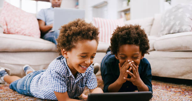 Children, floor and digital tablet in living room, watching fun or education videos, funny cartoon or playing game online. Technology, internet or black boys play on carpet with mobile app together stock photo