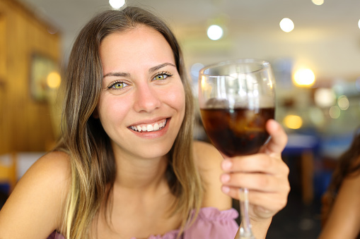 Happy teen holding soda cup toasting with tou