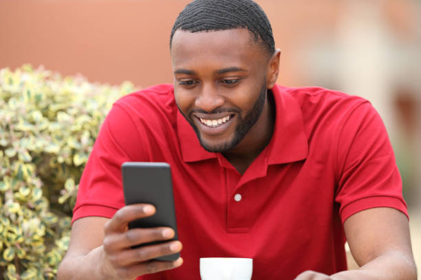 istock Happy black man checks cell phone in a bar 1439706641