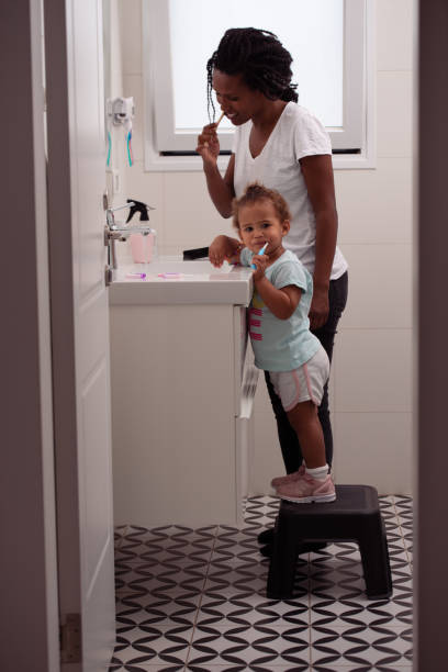 istock Mom and daughter brushing teeth in the morning routine. 1439708364