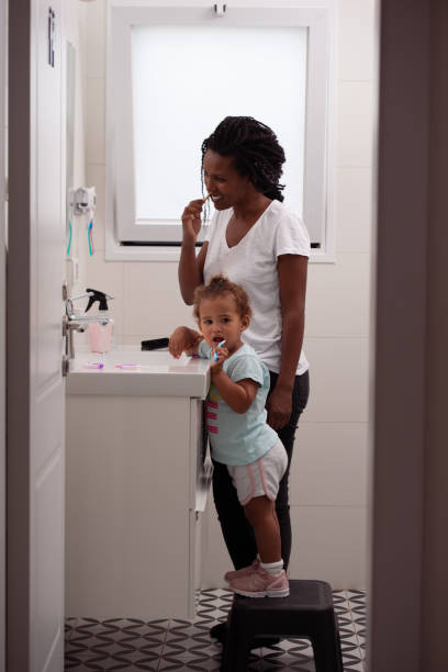 istock Mom and daughter brushing teeth in the morning routine. 1439708455
