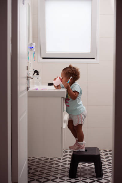 朝、口をすすぎ、歯を磨く少女。 - bathroom sink window bathroom house ストックフォトと画像