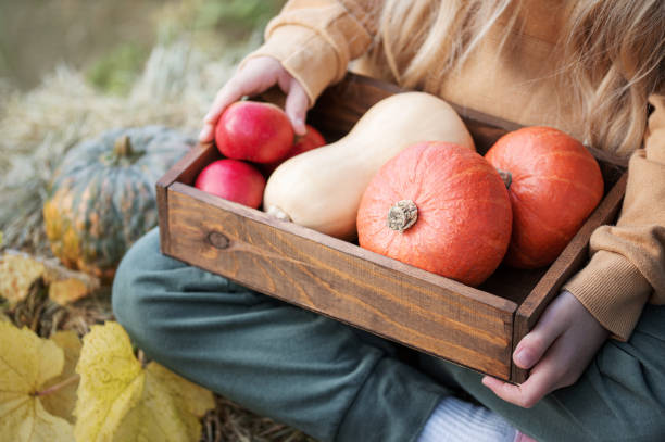 istock Girl in the hay with pumpkins 1439710084
