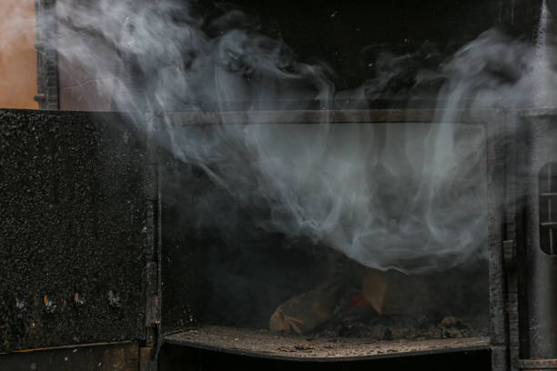 istock Thick smoke billows from a coal stove in close-up. 1439711898