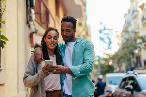 istock African American couple using mobile phone in city. 1439715471