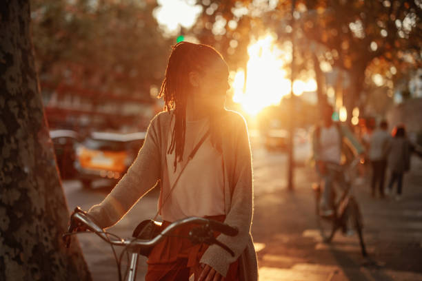 istock Woman with bicycle in the sunset. 1439715502