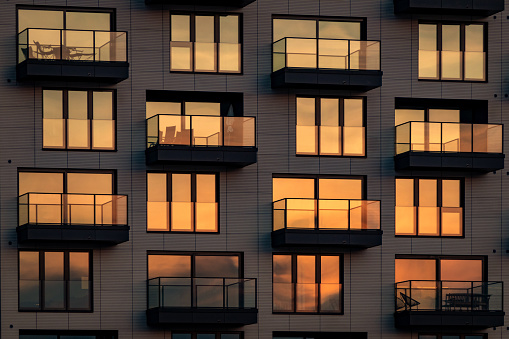 Modern glass facade with balconies in the heat of the evening sun