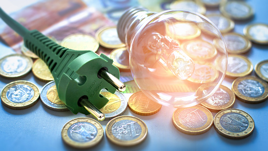 Lightbulb and plug on euro coins and banknotes 16:9 format
