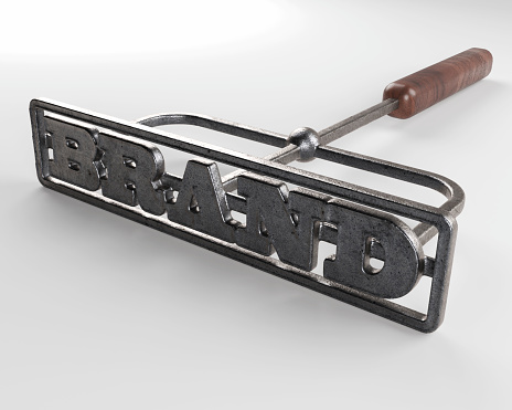 A metal cattle branding iron with the word brand as the marking area on an isolated white surface - 3D render
