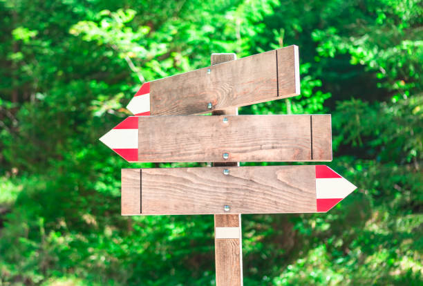 Wooden arrow boards . Wood arrow signs for tourists . Direction indicators for hiking