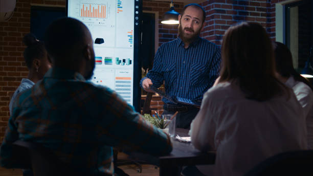 istock Businessman presenting analytics research, showing statistics on laptop screen 1439723167