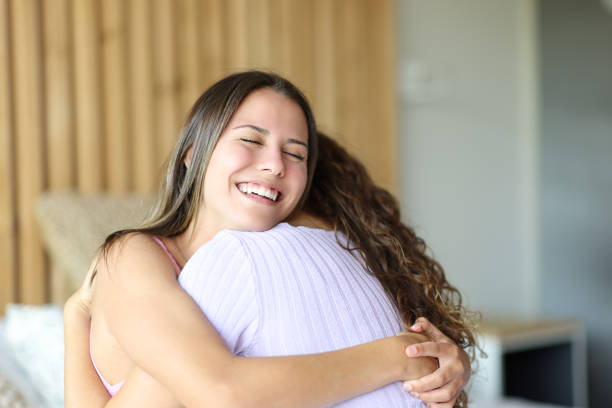 istock Happy friends hugging in a room 1439725037