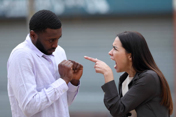 une femme gronde un homme noir dans la rue - violence black men women photos et images de collection