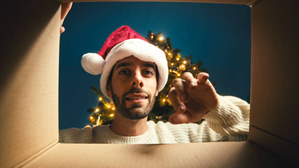 istock Happy guy opens and looks inside a Christmas box 1439733259