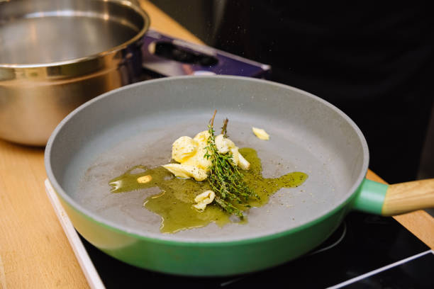 Butter with garlic and thyme in a pan. stock photo