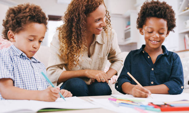 Children, drawing and learning art with pencil in book and mother helping with homework, education and writing. Happy black family and woman teacher with kids for lesson on creativity development stock photo