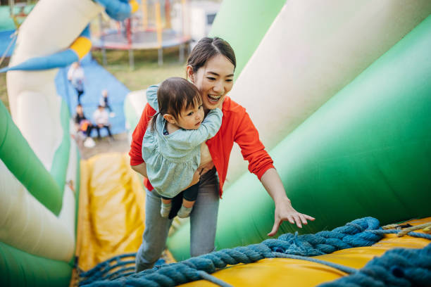 s'amuser au parc d'attractions - inflatable slide sliding child photos et images de collection