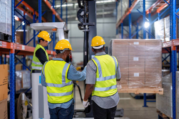 afroamericanos que trabajan en almacén sostienen luz roja dar señal a camión cargando caja de cartón - african descent factory accuracy analyzing fotografías e imágenes de stock