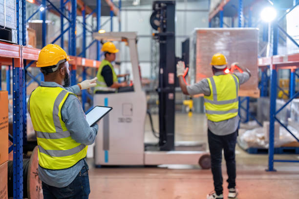 los afroamericanos que trabajan en el almacén mantienen el stock de tabletas mientras el camión carga la caja de cartón cerca - african descent factory accuracy analyzing fotografías e imágenes de stock