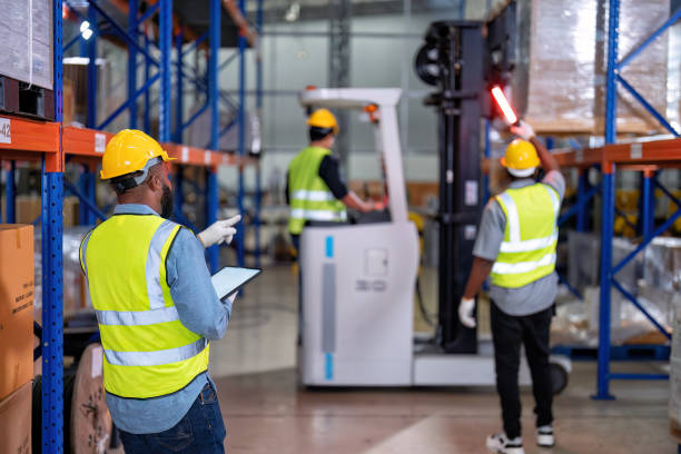 african american working in warehouse hold tablet stock check while truck loading carton box near by - african descent factory accuracy analyzing imagens e fotografias de stock