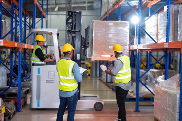 african american working in warehouse hold tablet stock check while truck loading carton box near by - african descent factory accuracy analyzing imagens e fotografias de stock