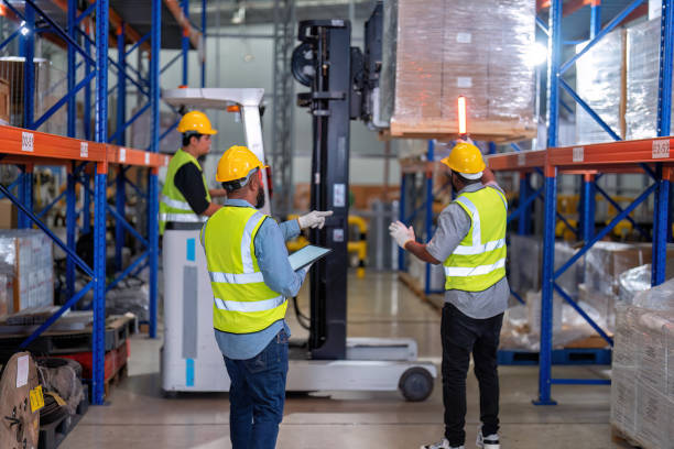 african american working in warehouse hold tablet stock check while truck loading carton box near by - african descent factory accuracy analyzing imagens e fotografias de stock