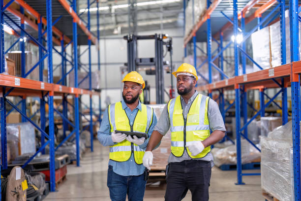 afroamericanos que trabajan en almacén sostienen luz roja dar señal a camión cargando caja de cartón - african descent factory accuracy analyzing fotografías e imágenes de stock