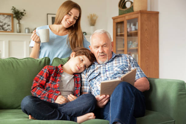 Multi-generation happy family reading book together at home