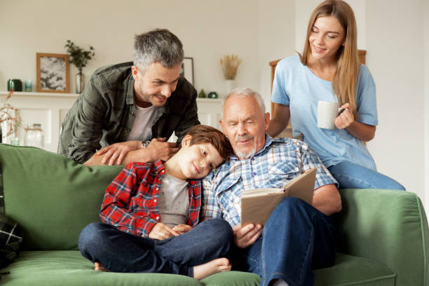 istock Multi-generational happy family reading book together. Education concept 1439752350