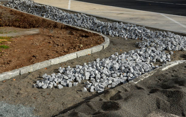 pavers made of stone cubes who can create beautiful mosaics. piles prepared in fine gravel for laying between curbs. the mayor ordered new sidewalks from the construction company pavers made of stone cubes who can create beautiful mosaics. piles prepared in fine gravel for laying between curbs. the mayor ordered new sidewalks from the construction company, chipped, pavers, unfinished pavement ends sign stock pictures, royalty-free photos & images