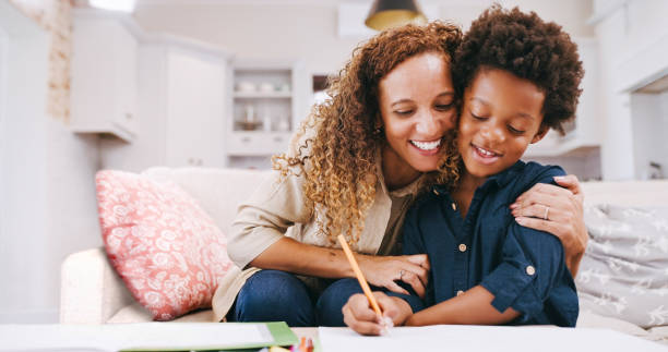 Mother, child and helping with homework for education and learning at home while writing in a notebook. Woman helping her son with schoolwork while tutoring for knowledge at school or assignment madre, hijo y ayudando con la tarea para la educación y el aprendizaje en casa mientras escribe en un cuaderno. mujer negra ayudando a su hijo con las tareas escolares mientras da clases particulares de conocimiento en la escuela o en la tarea