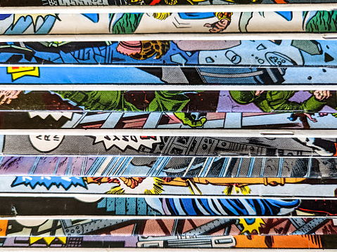 La colección de cómics vintage apilados en una pila crea un patrón de fondo de líneas y formas coloridas en papel viejo photo