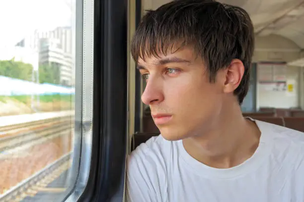 Pensive Young Man sit in the Train