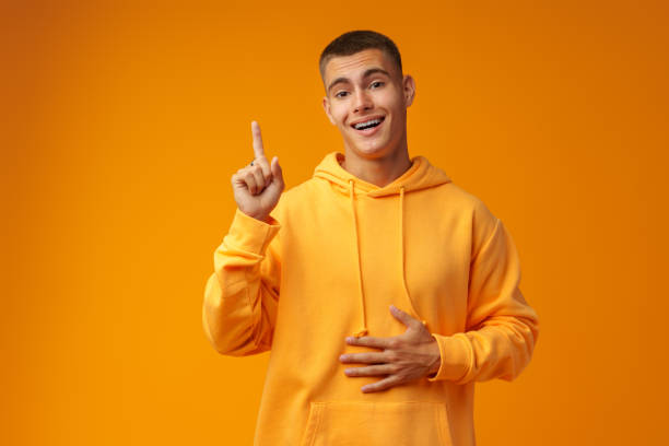 istock Handsome young man pointing to copy space on a yellow background 1439763281