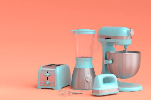 Electric blender for making healthy smoothie, hand mixer and toaster on coral stock photo