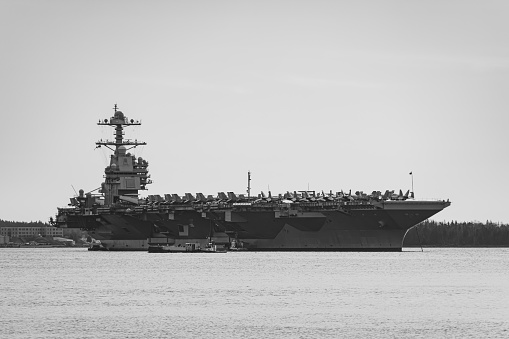 American aircraft carrier anchored in a harbour after offshore training exercises.