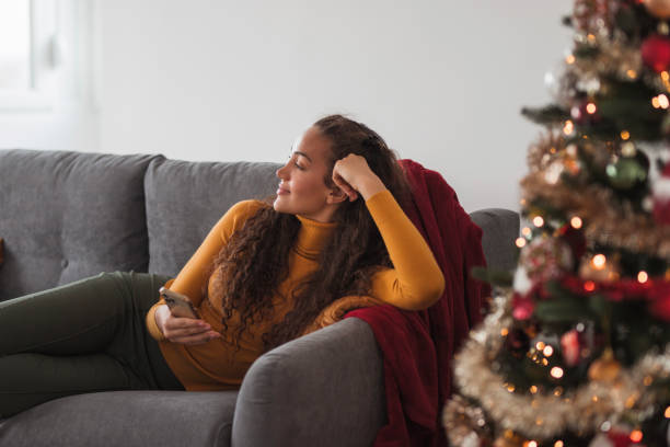 istock Cheerful young woman leaning head over hand and using smart phone 1439768663