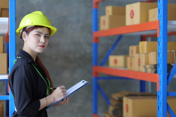 istock Female warehouse worker inspecting parcels on a shelf in a small warehouse. 1439768874