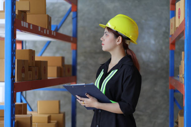 istock Female warehouse worker inspecting parcels on a shelf in a small warehouse. 1439768883
