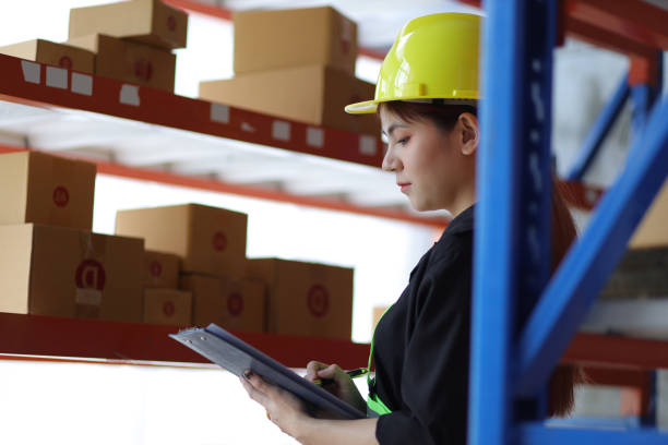 istock Female warehouse worker inspecting parcels on a shelf in a small warehouse. 1439768898