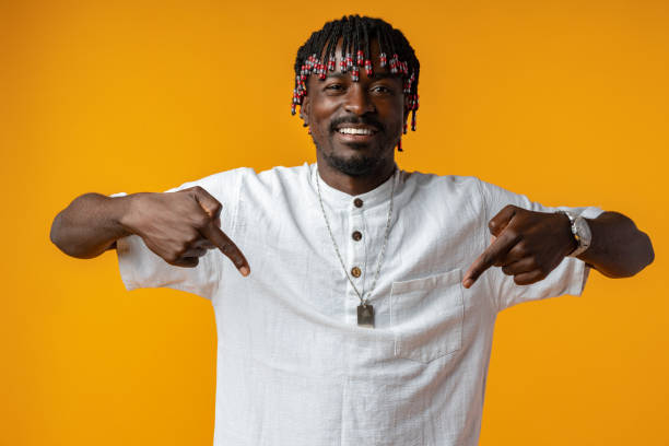istock Happy african man standing on yellow background pointing down 1439769092
