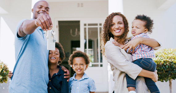 Real estate, new home and black family on property with key, renting or buying house. Home loan, investment and building mortgage with happy man, kids and mother standing outdoor with house keys.