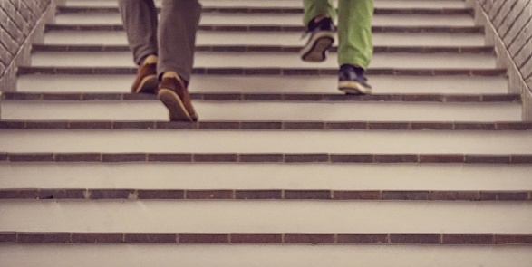 A closeup shot of feet of two males going up the stairs