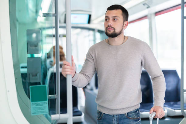 istock Young bearded man with suitcase riding in streetcar 1439772350