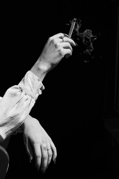 istock Woman's Hand Holding Marijuana THC CBD Joint in Black and White 1439772511