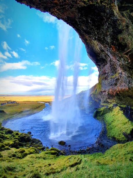 istock Vertical shot of a waterfall with a blue sky background 1439773448