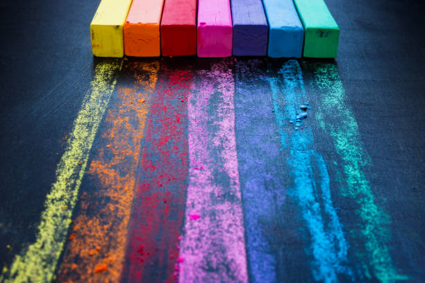 istock Colored crayons and a rainbow on a black board. Unity and diversity concept. 1439773596