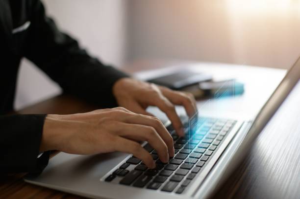 istock Man typing on a laptop keyboard which releases a 3D-rendered digital document 1439773909