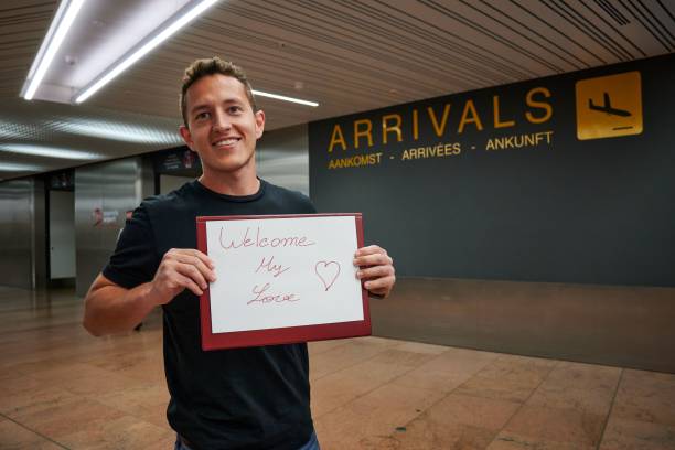 空港でウェルカム・マイ・ラブ・テキストの看板を持つ若い幸せなヒスパニック系男性 - welcome sign ストックフォトと画像